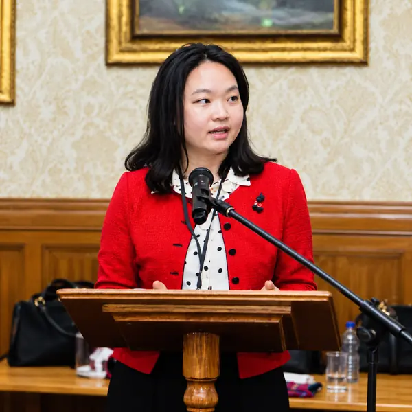 Speaker in a red jacket at a lectern