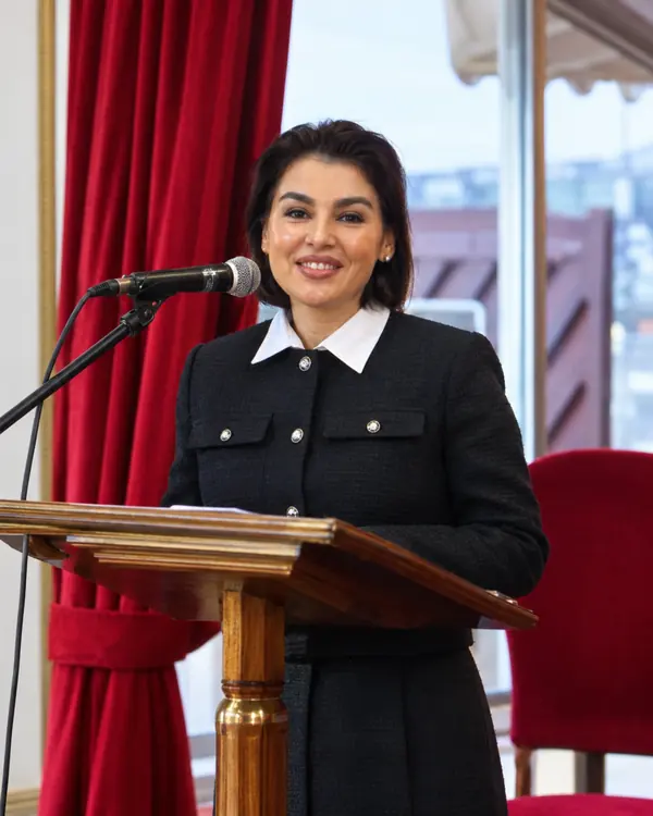 Speaker in a black jacket smiling at the podium