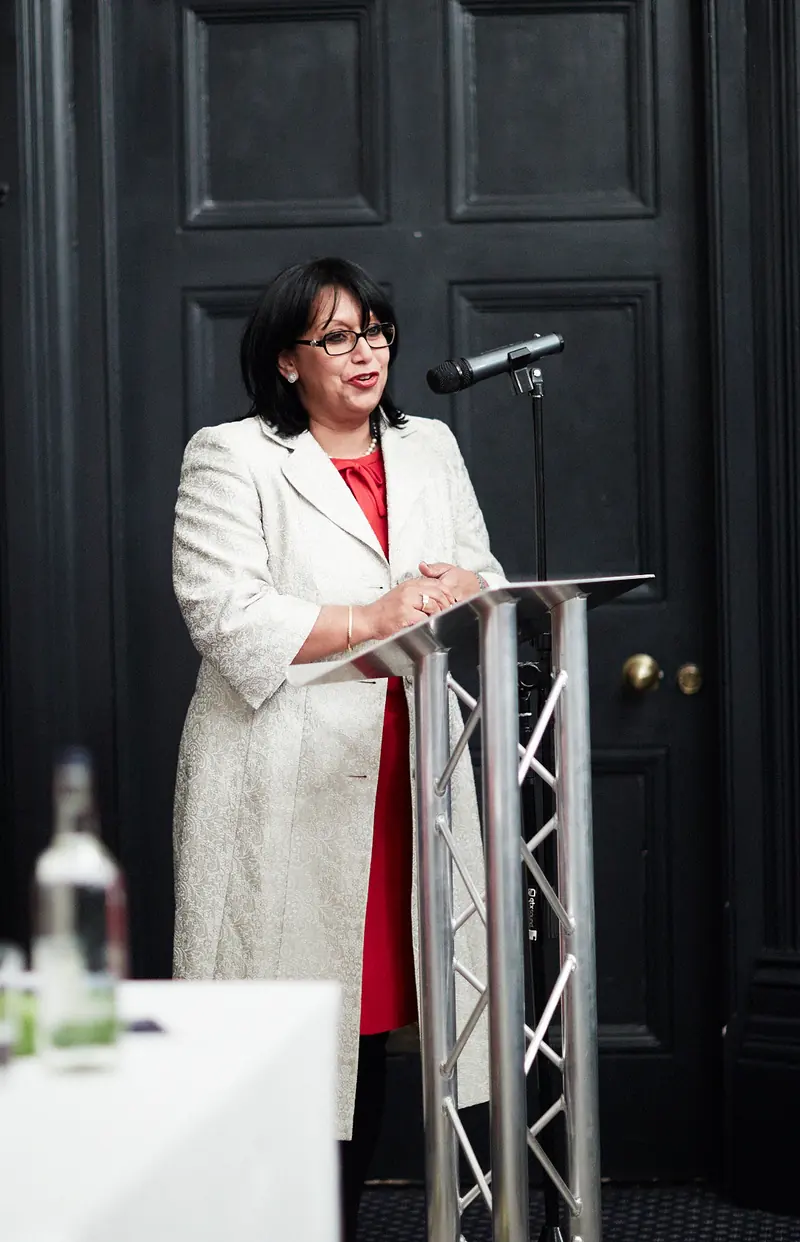 A speaker addressing the room from a lectern
